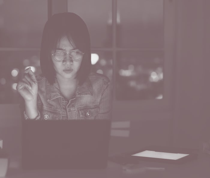 Candid of young attractive asian female student sitting on desk with smart digital gadget looking at...