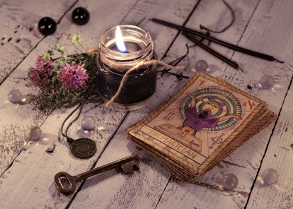Black candle and old tarot cards on wooden planks. Halloween and fortune telling concept. Mystic bac...