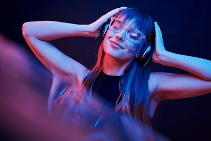 Stylish glasses. Studio shot in dark studio with neon light. Portrait of young girl.