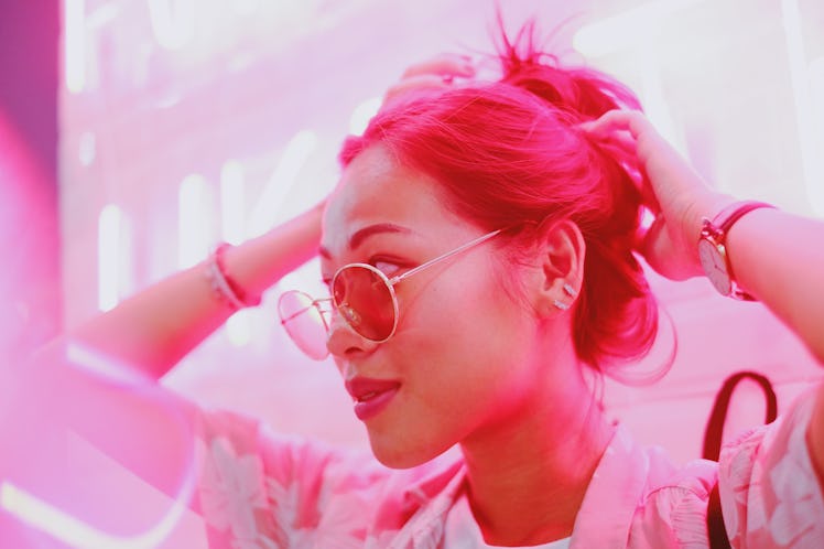 Young woman in pink neon light during the October 2021 full moon in Aries, which will affect her zod...