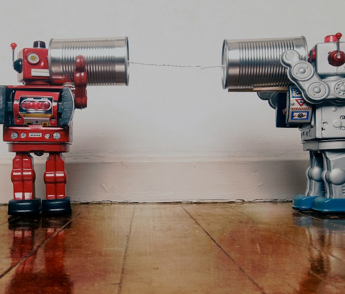 tow retro robots talk on tin can phones on an old wooden floor with reflection