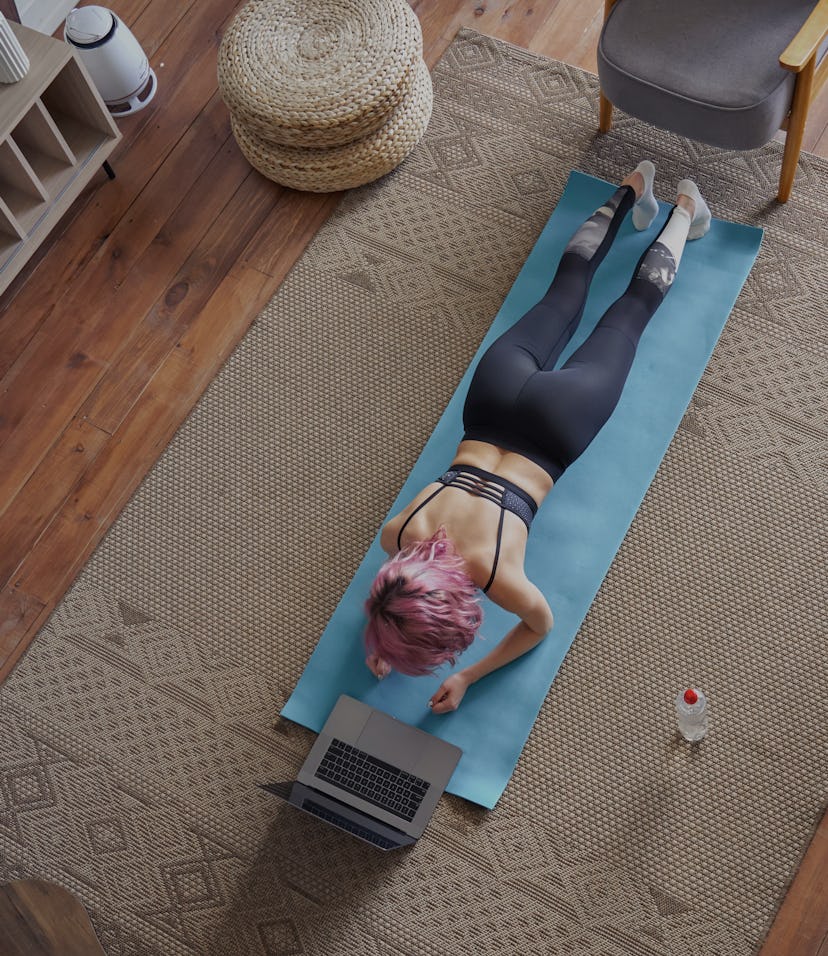 Young healthy sporty fit woman pink hair wear sportswear do plank sport training exercise watch onli...