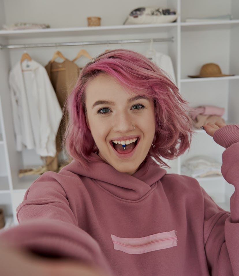 Excited hipster gen z teen girl fashion social media channel blogger stylist with pink hair piercing...