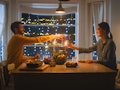 Happy Young Couple in Love Have Romantic Dinner, Toasting Each other with Glasses of Wine, Eating Ta...