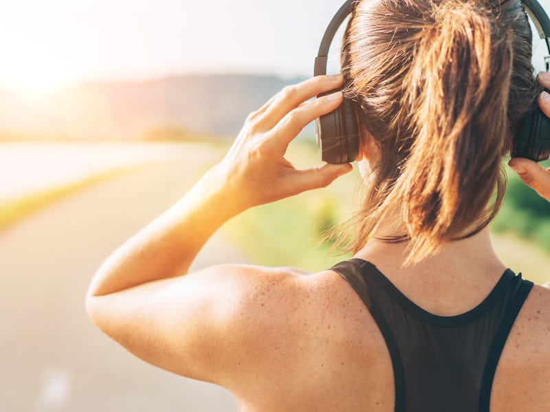 Close up image of teenager adjusting  wireless headphones before starting jogging and listening to m...