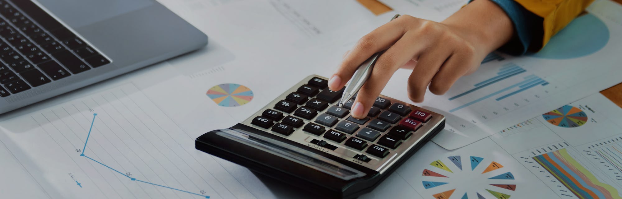 Woman accountant use calculator and computer with holding pen on