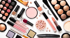 Decorative cosmetics and makeup brushes on a white background, top view