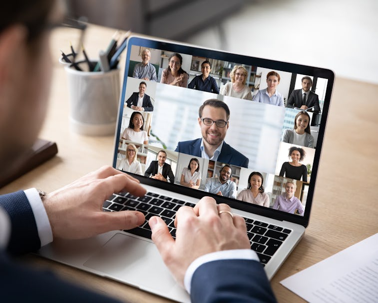 Rear view of businessman speak on web conference with diverse colleagues using laptop Webcam, male e...