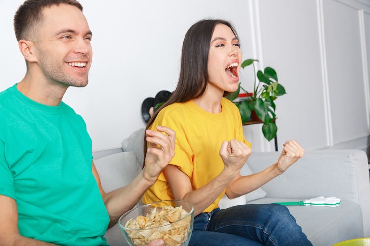 Young couple sport fans watching match supporting team close-up