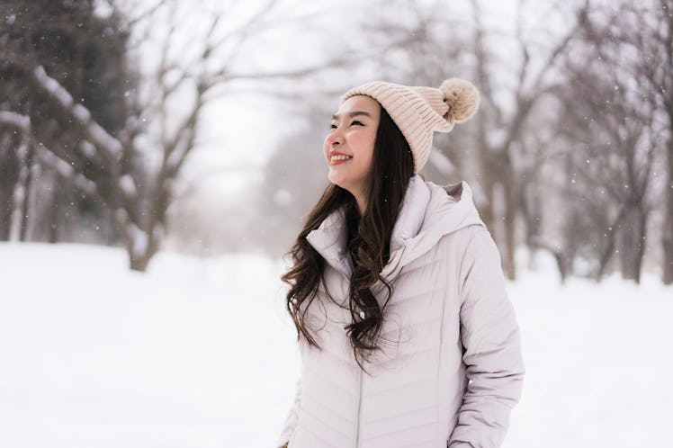Beautiful young asian woman smiling happy with travel in snow winter season at Hokkaido Japan
