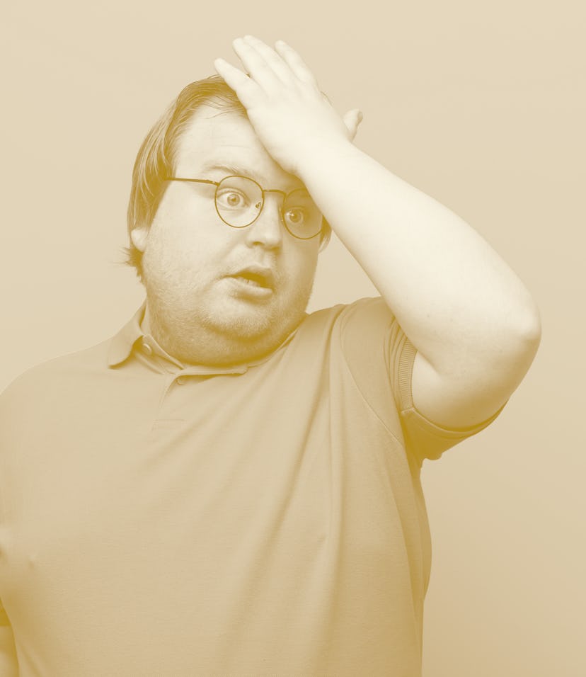 young big size man raising palm to forehead thinking oops, after making a stupid mistake or remember...