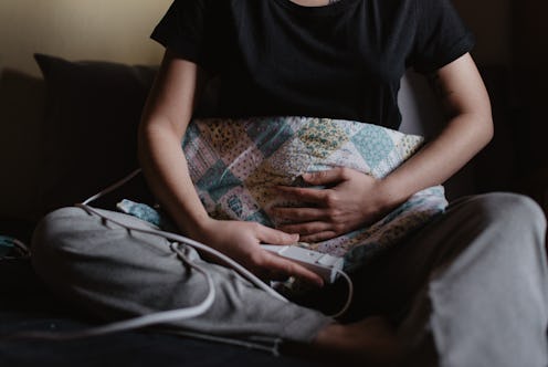 A girl holding an electrical blanket on her stomach