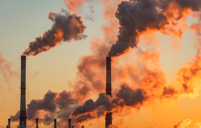 Aerial view of high smoke stack with smoke emission. Plant pipes pollute atmosphere. Industrial fact...