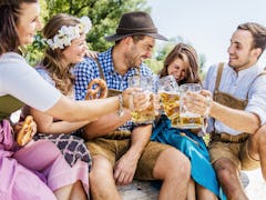 Five friends having fun on Bavarian RIver and clinking glasses with Oktoberfest 