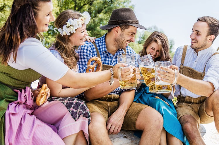 Five friends having fun on Bavarian RIver and clinking glasses with Oktoberfest 