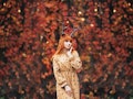 woman with deer makeup and horns in autumn forest during halloween