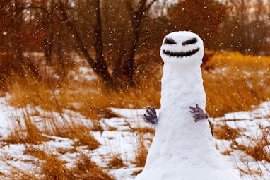 scary snowman as a monster on a background of yellow grass. Halloween