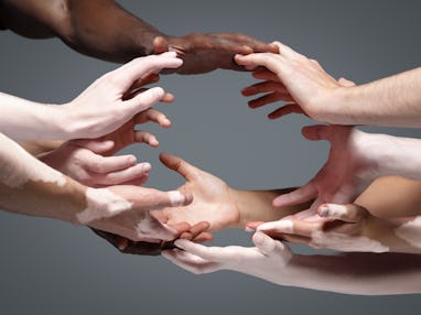 Planet Earth. Hands of different people in touch isolated on grey studio background. Concept of rela...