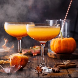 Autumn pumpkin cocktail on wooden table. 