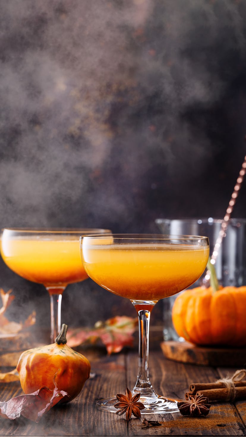 Autumn pumpkin cocktail on wooden table. 