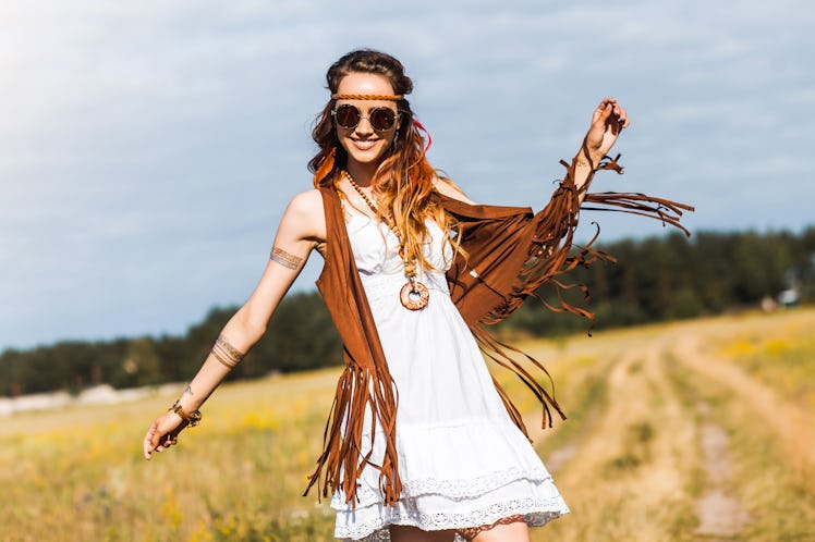 Pretty amazing free red-haired hippie girl dancing outdoors, feathers and braids in her hair, white ...