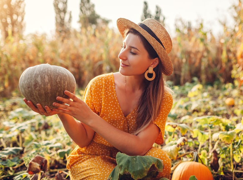Young woman holding gourd, thinking about how her zodiac sign will have the best Thanksgiving 2021