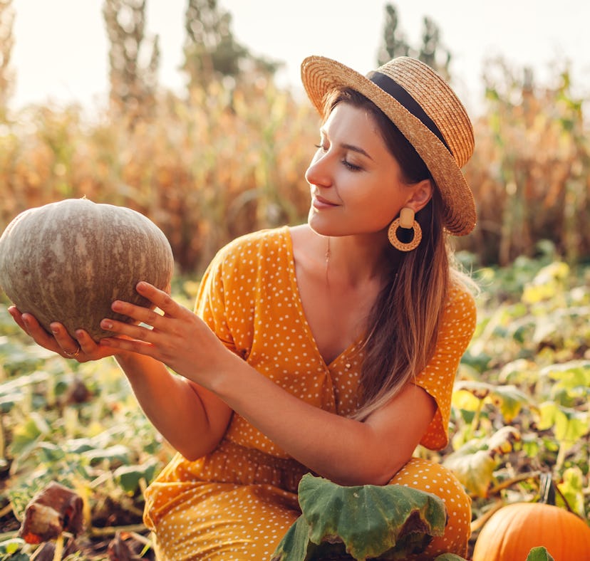 Young woman holding gourd, thinking about how her zodiac sign will have the best Thanksgiving 2021