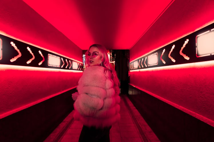 Young woman walking down a hallway filled with red lighting after reading her January 3, 2022 weekly...