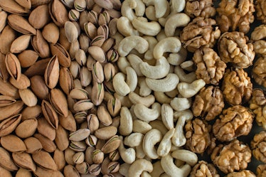 Assorted nuts almonds, pistachio, cashews, walnut. Flatly organic mixed nuts background. Healthy foo...