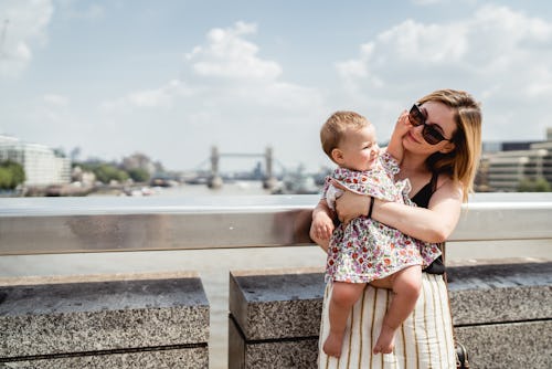 Mother with a daughter are staying and posing on the bridge in London.