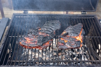 overcooked ruined black bbq ribs on the charcoal grill