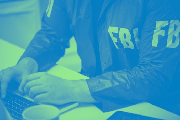 Cropped photo of FBI agent using laptop in office