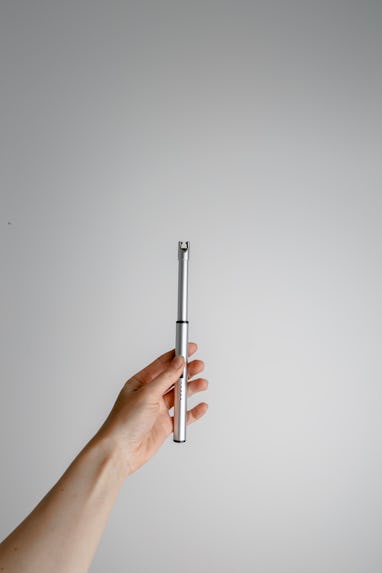 Woman hand holding a plasma lighter. White background.