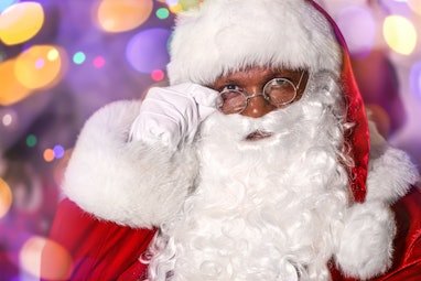 African-American Santa Claus against blurred lights