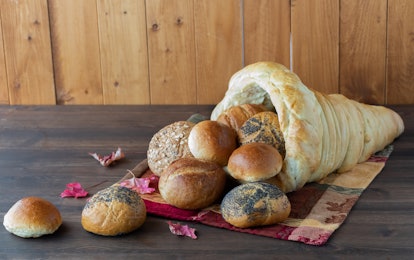 Straight on view of a homemade bread cornucopia with rolls spilling out.