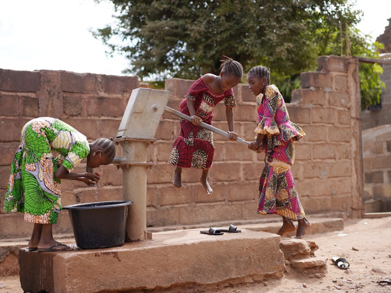 African Girls Having Trouble In Pumping Water Out Of An Almost Dry Public Well