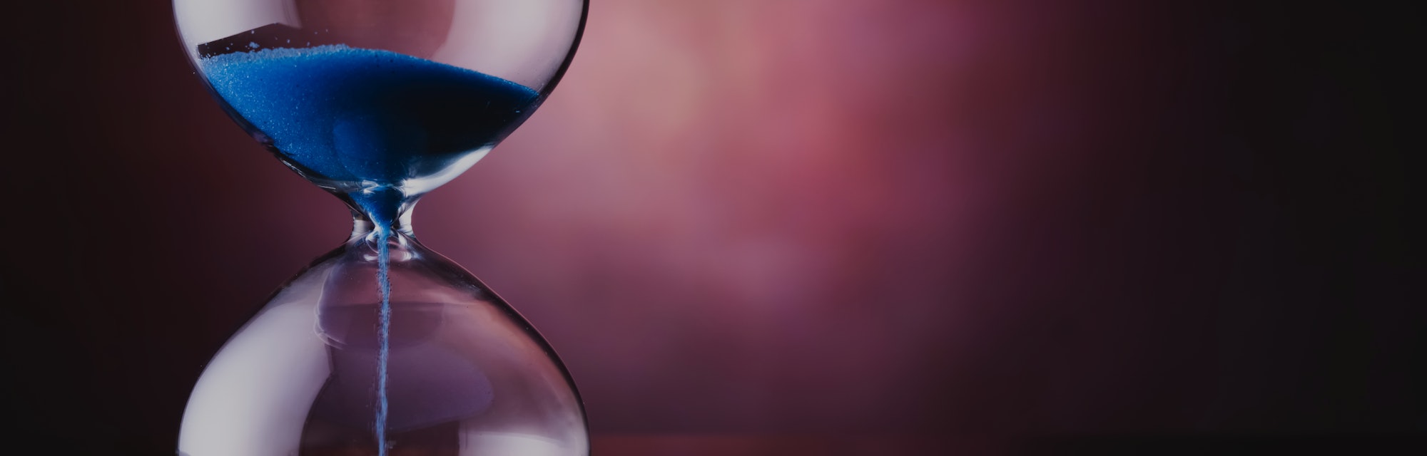 Blue sand hourglass on old background