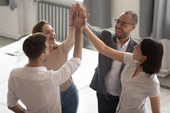 Happy motivated diverse business work team people employees group giving high five together engaged ...