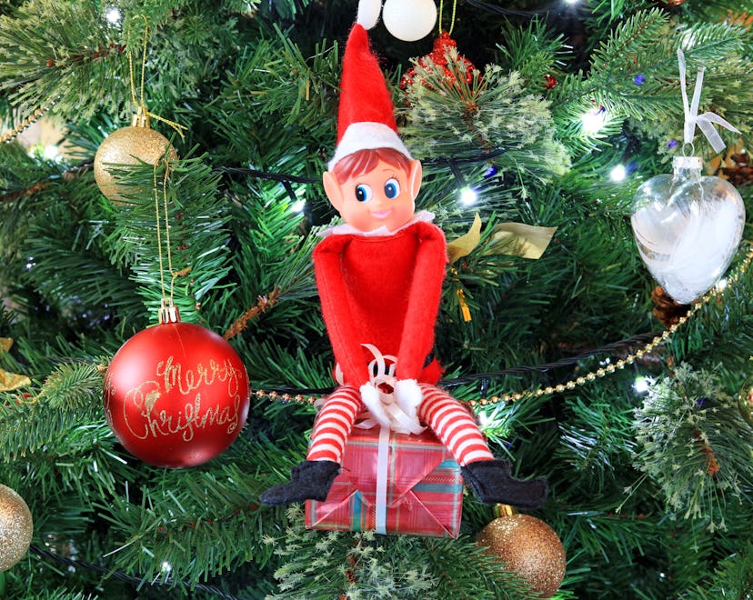 Naughty Christmas Elf Sat On A Present Up To Mischief.