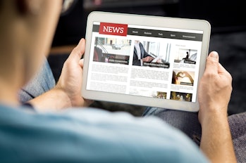 Online news article on tablet screen. Electronic newspaper or magazine. Latest daily press and media...