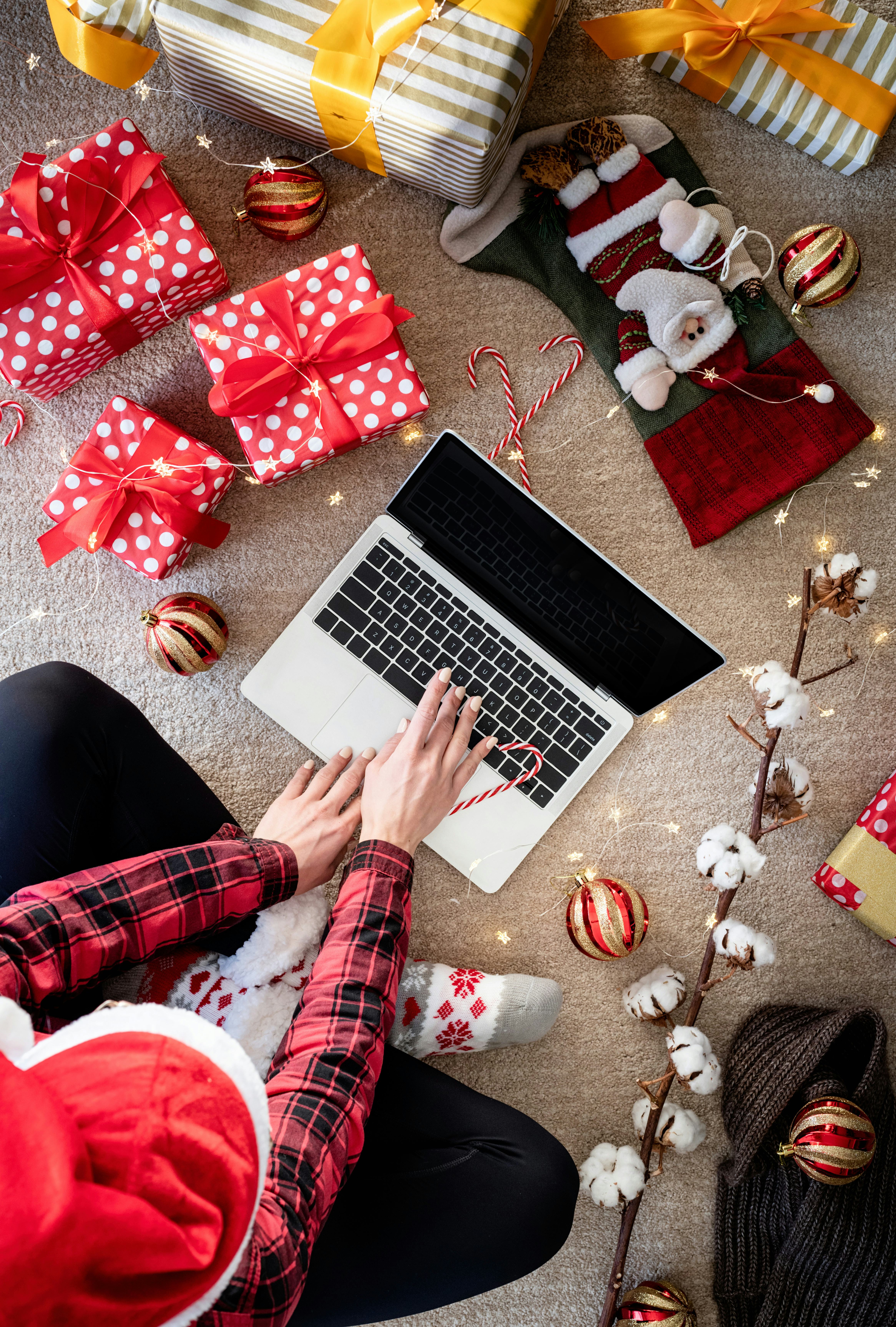 Top view of woman shopping online at christmas holidays holding a present. Christmas online shopping