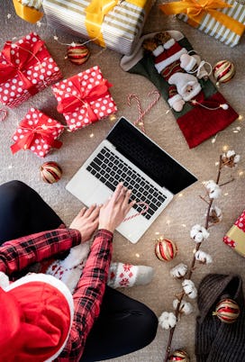 Top view of woman shopping online at christmas holidays holding a present. Christmas online shopping