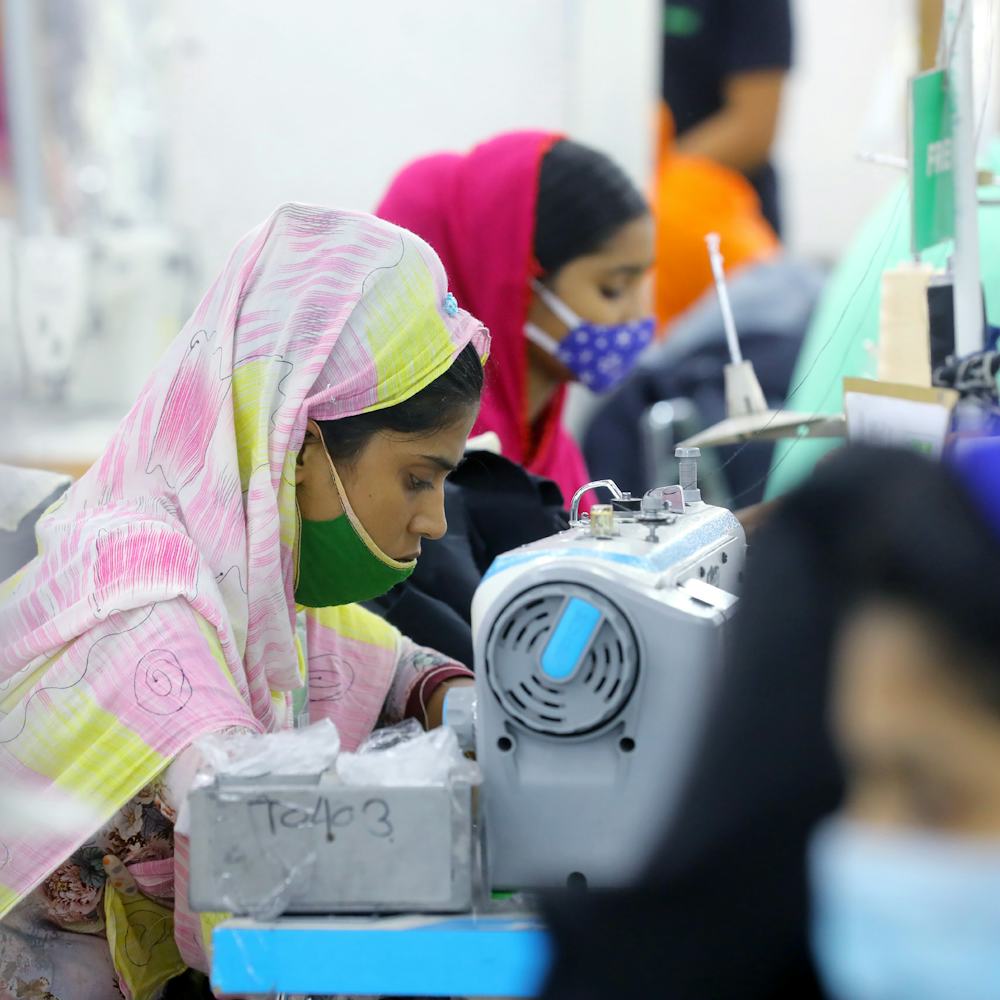 A Woman worker wears face mask as preventive measure while manufactures clothes in a garment factory...