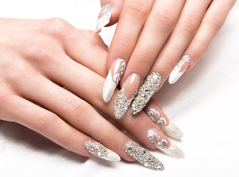 Rhinstoned and glitter nails with an updated french manicure style on hands.