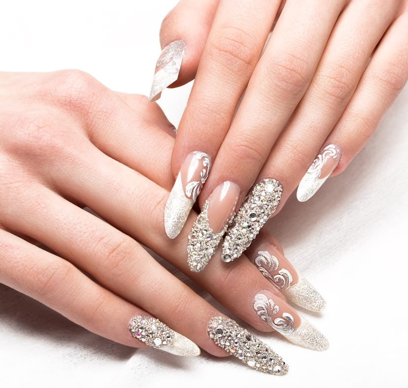 Rhinstoned and glitter nails with an updated french manicure style on hands.