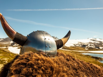 Viking helmet and brown fur on mountains nature in Norway. Tourism and traveling concept