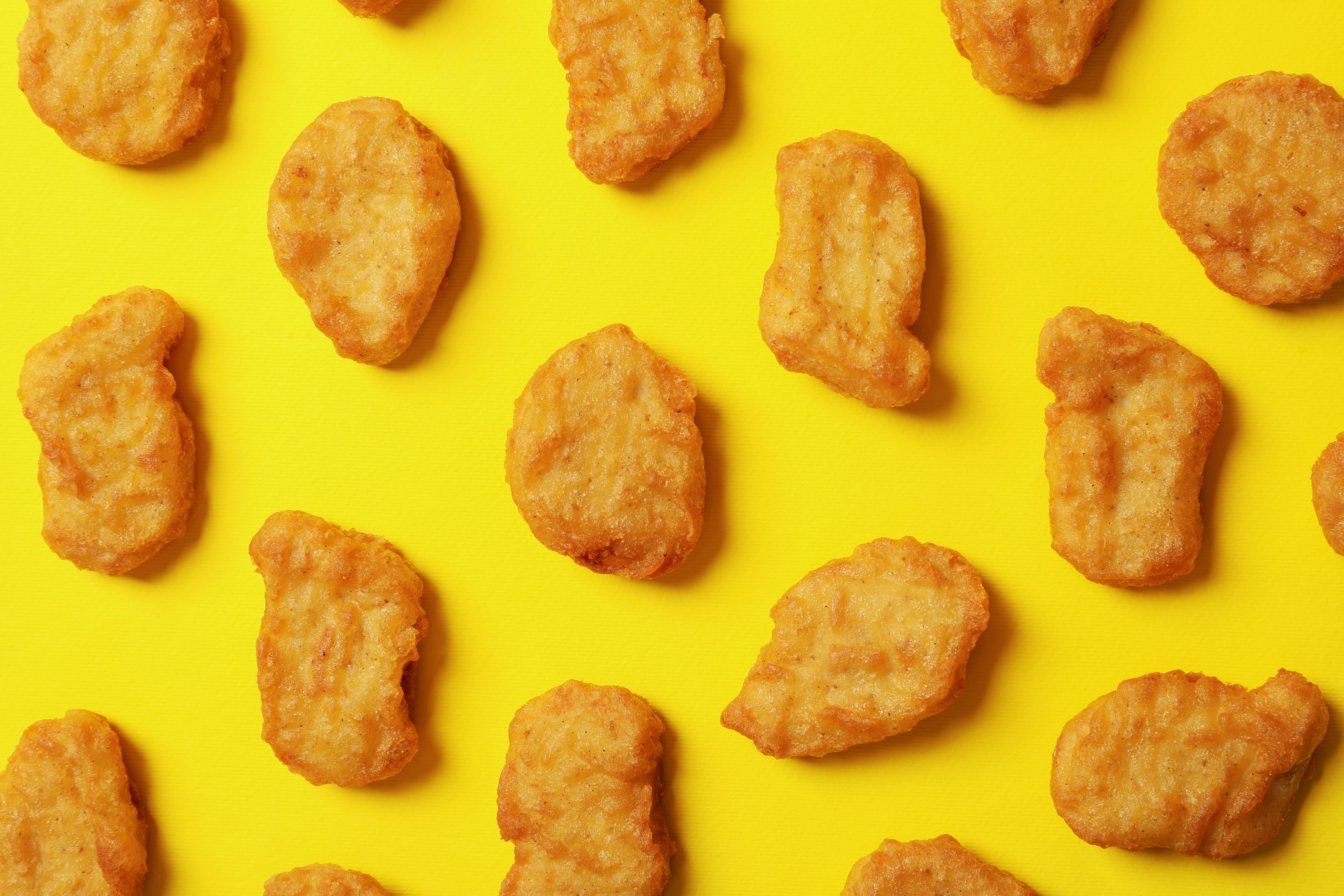 Flat lay with fried chicken nuggets on yellow background
