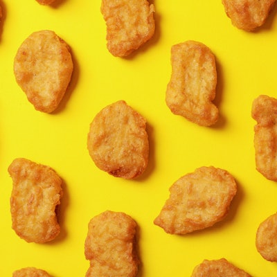 Flat lay with fried chicken nuggets on yellow background