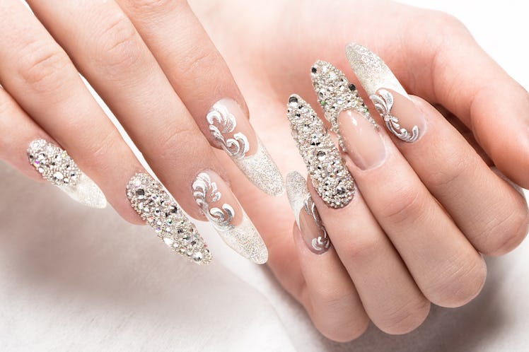 A modern French manicure with rhinestones and glitter.
