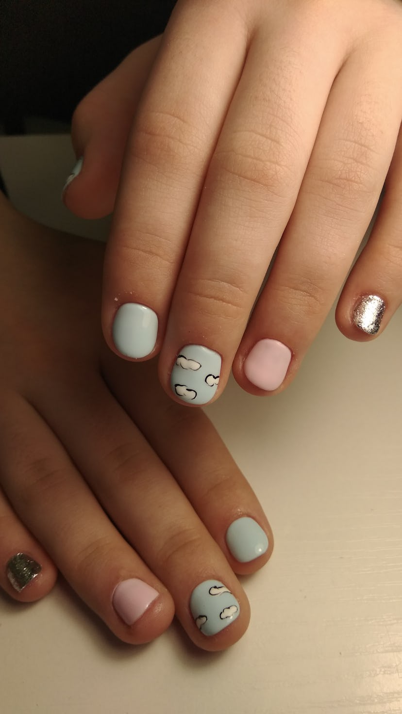 Hands with a cloud manicure.